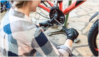 Person wearing black gloves working on the Tongsheng TSDZ2B e-bike motor with a tool.