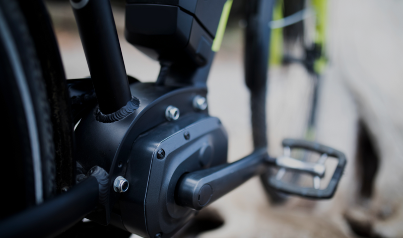 Close-up view of the motor and crankset area of an electric bicycle,