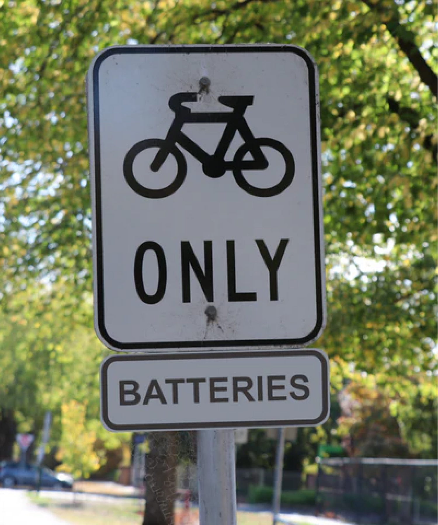 Bicycle parking sign indicating 'ONLY BATTERIES' with a bicycle symbol above the text.
